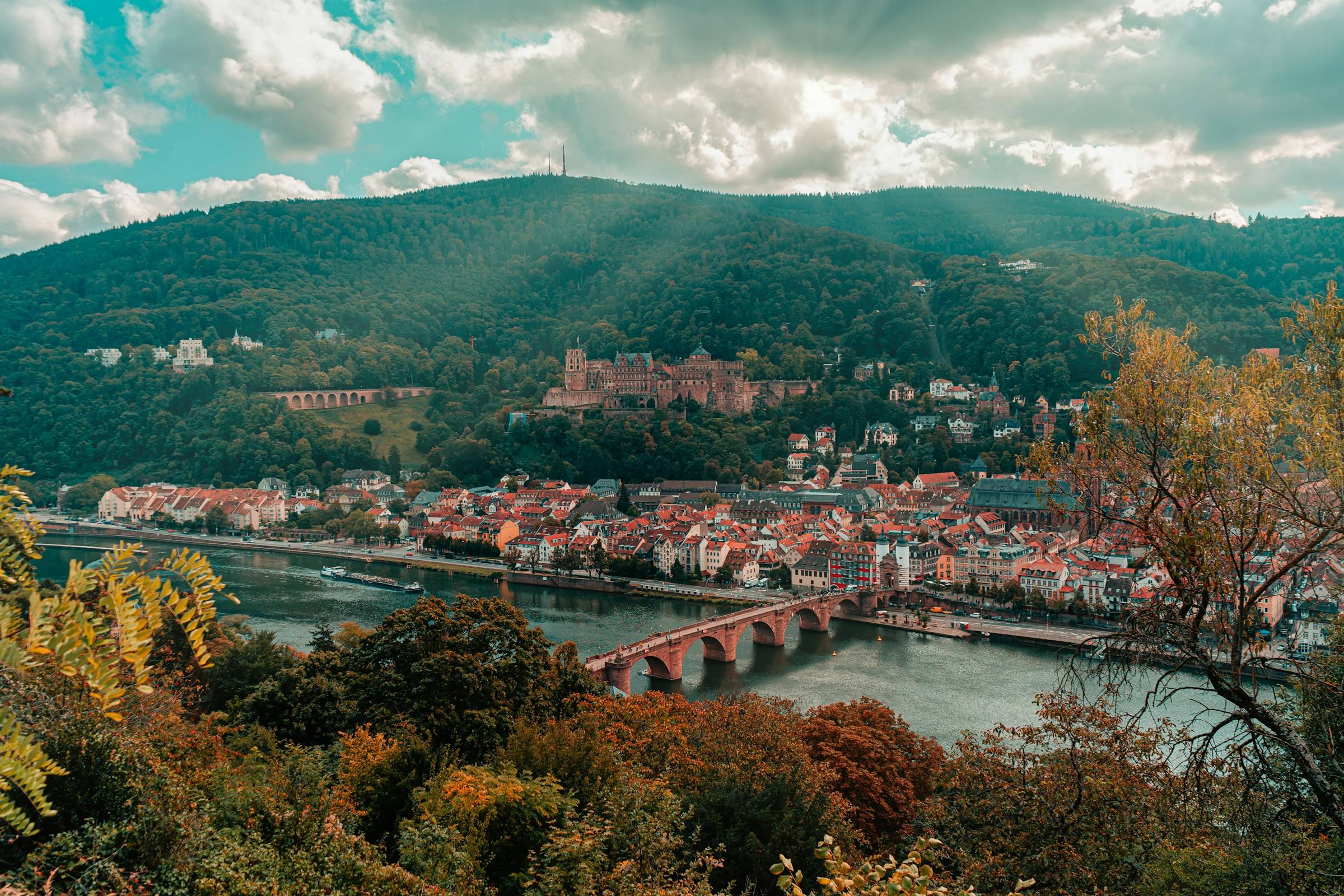 Herbstlicher Blick über den Neckar auf die Alte Brücke, die Heidelberger Altstadt und das Schloss am Hang